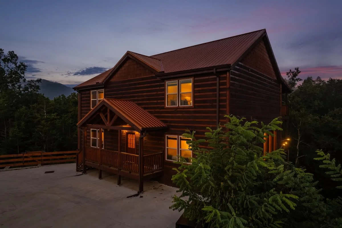 Blue Smoke Lodge at dusk against the Smoky Mountain treeline